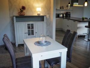 a white dining room table with chairs and a kitchen at Dorfidylle - Thüringer Wald Rennsteig in Friedrichroda +11 photos