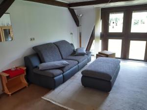 a living room with a couch and a ottoman at Ferienwohnung Stockemer Haecke in Stockheim