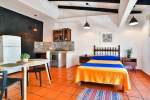 a bedroom with a bed and a table and a kitchen at Hotel Villa del Mar Tradicional in Puerto Vallarta +43 photos