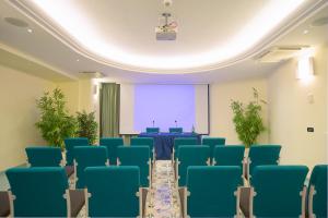 a conference room with blue chairs and a projection screen at Le Querce Resort Sea Thermae & Spa in Ischia