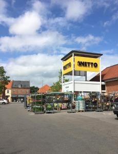 een winkel met een antidepressivo bord op een parkeerplaats bij Rødby Købstadshotel in Rødby