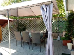 a table and chairs under a umbrella on a patio at Apartments Rina in Rovinj