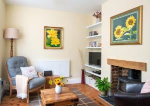 a living room with a fireplace and a tv at Magnolia Cottage in Church Stretton