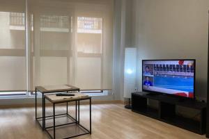 a living room with a flat screen tv and a table at New Studio Sito 8 Parking Gratis in Salamanca