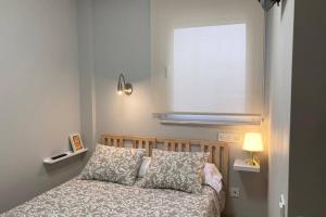 a bedroom with a bed and a lamp and a window at New Studio Sito 8 Parking Gratis in Salamanca