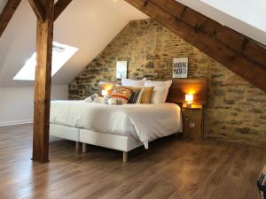 a bedroom with a bed and a stone wall at Appartement en duplex centre-ville BOHEME in Vannes