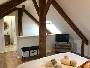 een slaapkamer op zolder met een bed en een televisie bij Appartement en duplex centre-ville BOHEME in Vannes