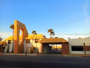 un bâtiment avec un panneau en face d'une rue dans l'établissement HOTEL POSADA DEL DESIERTO, à Heroica Caborca