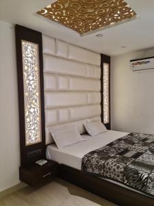 a bedroom with a bed and two windows at Hotel Star Inn in Gangānagar