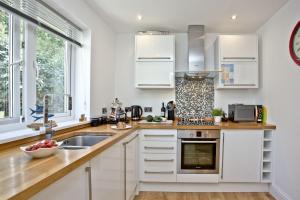 a kitchen with white cabinets and a sink at 19 At The Beach, Torcross in Beesands
