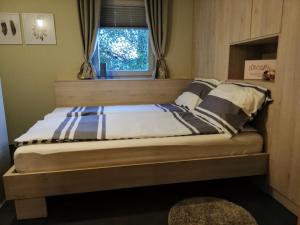 una cama en una habitación con ventana en Fajn Apartment, en Šempeter v Savinjski Dolini