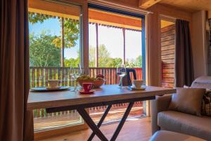 a wooden table with a glass of wine on a porch at Borgo Stazione Bike Inn in Valeggio sul Mincio