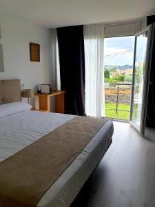 1 dormitorio con cama grande y ventana grande en Hotel Finca Alcamino en Mompía