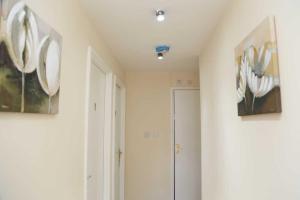 a room with two paintings on the wall and a door at Budget 4-Bedrooms In Thamesmead in London