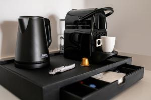 a coffee maker and a cup on a black shelf at Hotel Fariones in Puerto del Carmen