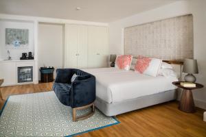 a bedroom with a large bed and a chair at Hotel Fariones in Puerto del Carmen