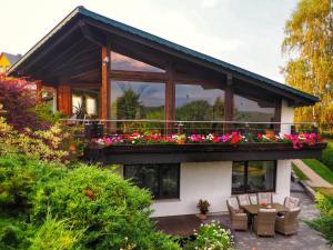 uma casa com uma varanda com flores em Dorfidylle - Thüringer Wald Rennsteig em Friedrichroda