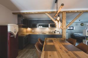 uma cozinha e sala de jantar com uma mesa de madeira em Modernes Loft vor den Toren des Chiemgaus em Tacherting
