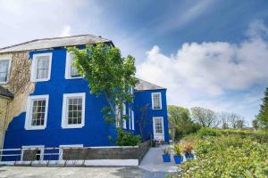 a blue house with white windows at Granville House Apartments in Ballyferriter