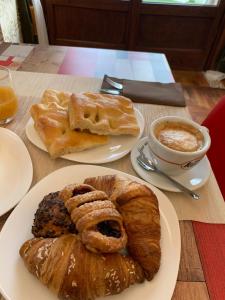- une table avec deux assiettes de pâtisseries et une tasse de café dans l'établissement Domus Victoria, à Gênes