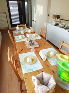 - une table en bois avec des assiettes dans la cuisine dans l'établissement Opera B&B, à Foggia