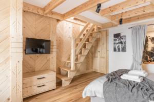 ein Schlafzimmer aus Blockhaus mit einer Treppe und einem Bett in der Unterkunft Apartamenty w Chmurach in Kościelisko
