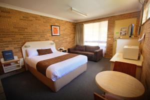 a hotel room with a bed and a couch at Garden City Motor Inn in Toowoomba