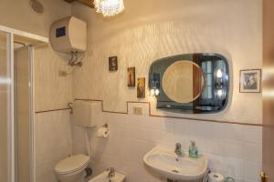 a bathroom with a toilet a sink and a mirror at B&B Due Borghi in Pisa
