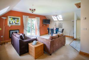 ein Wohnzimmer mit 2 Sofas und einem Kamin in der Unterkunft Berries Coach House in Church Stretton