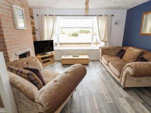 a living room with two couches and a tv at Ty Haf Summerhouse in Prestatyn