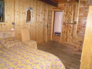 a bedroom with a bed and wooden walls at Gite Le Francillon in Les Estables