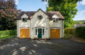 Casa blanca con puertas naranjas y entrada en Berries Coach House, en Church Stretton