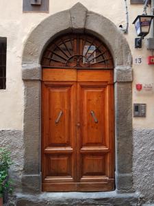 a wooden door in a building with an arch at B&B Due Borghi in Pisa