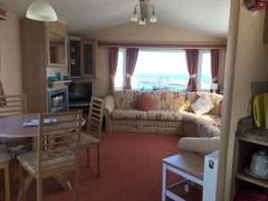 a living room with a couch and a table at Happy Days Holidays in Flamborough