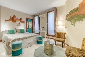 ein Schlafzimmer mit einem Bett, einem Stuhl und einem Tisch in der Unterkunft A due passi dal Castello in Ferrara