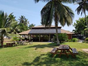 a building with a picnic table and a palm tree at Ko-Sa Beach Resort in Ampeni