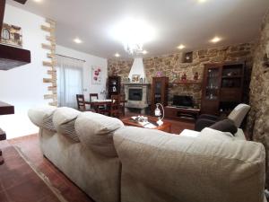 a living room with a couch and a stone wall at O Lar de Sara in Pontevedra