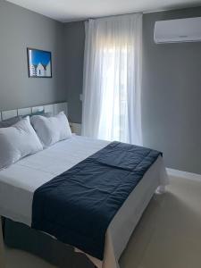 um quarto com uma cama grande e uma janela em Flat Edifício Royale 305 em Cabo Frio