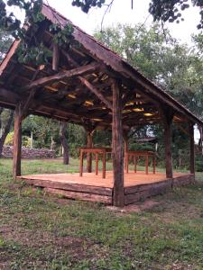 a wooden pavilion with benches in a park at The Carpathian Lodge in Runcu