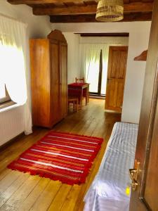 a living room with a red rug on a wooden floor at The Carpathian Lodge in Runcu
