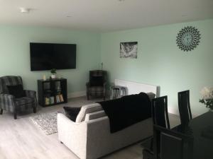 a living room with a couch and a flat screen tv at 1 Slieve Gullion View Killeavy Newry in Newry