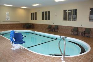 - une piscine avec une chaise dans la chambre dans l'établissement Holiday Inn Express - Ludlow - Chicopee Area, an IHG Hotel, à Ludlow