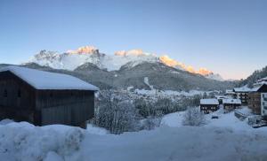 ein schneebedecktes Dorf mit einem Berg im Hintergrund in der Unterkunft Appartamenti Benvenuti in Padola