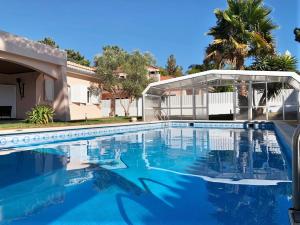 a swimming pool in front of a house at Moradia Pinhal da Telha in Corroios