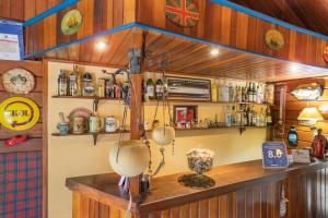a bar with wooden walls and a counter with utensils at Wood House in Itaipava