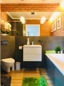 a bathroom with a tub and a toilet and a sink at Apartament MoLoo II in Ostróda +43 photos
