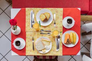 a table with plates of food on a red table at Wood House in Itaipava