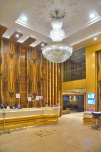 un gran vestíbulo con una lámpara de araña en un edificio en Hotel Aman Continental - Paharganj en Nueva Delhi