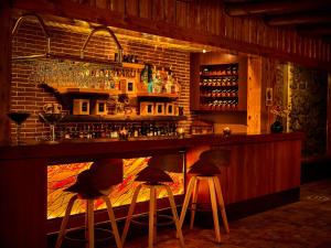 un bar con tres taburetes en una habitación en Hosteria Cabañas Del Lago, en Otavalo