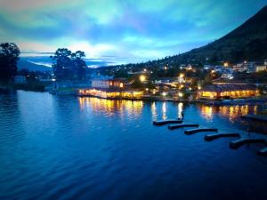 a view of a river at night with a town at Hosteria Cabañas Del Lago in Otavalo